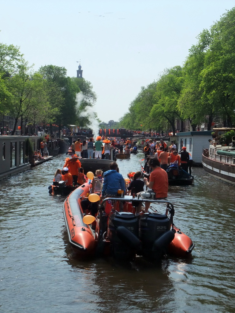 Tour boats at the Prinsengracht canal, with the bridge at the crossing of the Prinsenstraat street and the tower of the Westerkerk church
