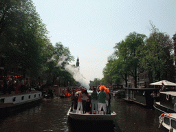 Tour boat at the Prinsengracht canal, with the tower of the Westerkerk church