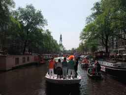 Tour boat at the Prinsengracht canal, with the tower of the Westerkerk church