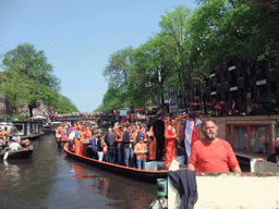 The skipper on the tour boat at the Prinsengracht canal with the bridge at the crossing of the Prinsenstraat street