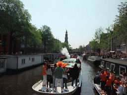 Tour boat at the Prinsengracht canal, with the tower of the Westerkerk church