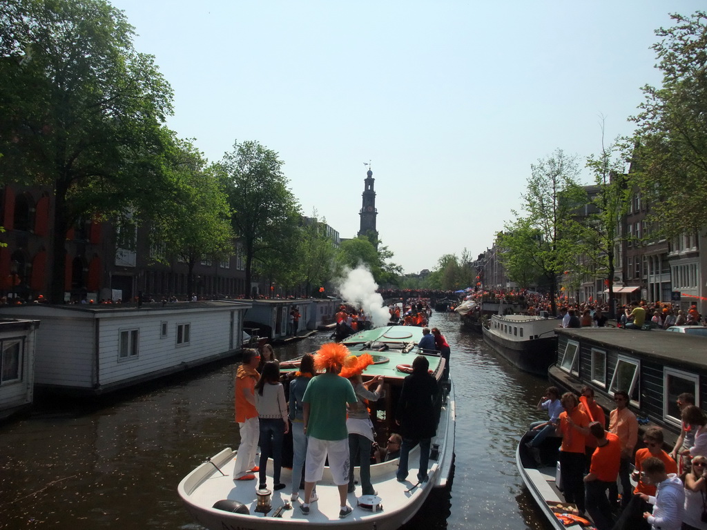 Tour boat at the Prinsengracht canal, with the tower of the Westerkerk church