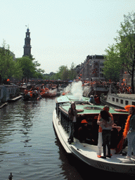 Tour boats at the Prinsengracht canal, with the bridge at the crossing of the Leliegracht canal and the tower of the Westerkerk church