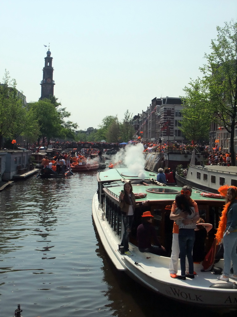 Tour boats at the Prinsengracht canal, with the bridge at the crossing of the Leliegracht canal and the tower of the Westerkerk church