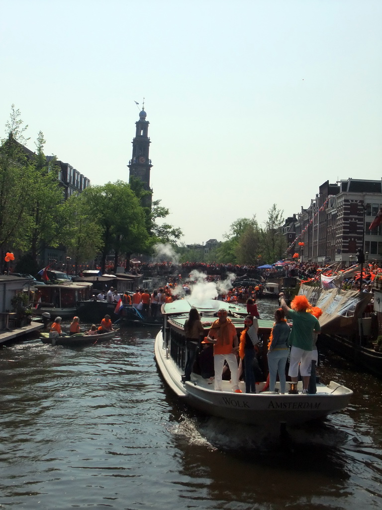 Tour boats at the Prinsengracht canal, with the bridge at the crossing of the Leliegracht canal and the tower of the Westerkerk church