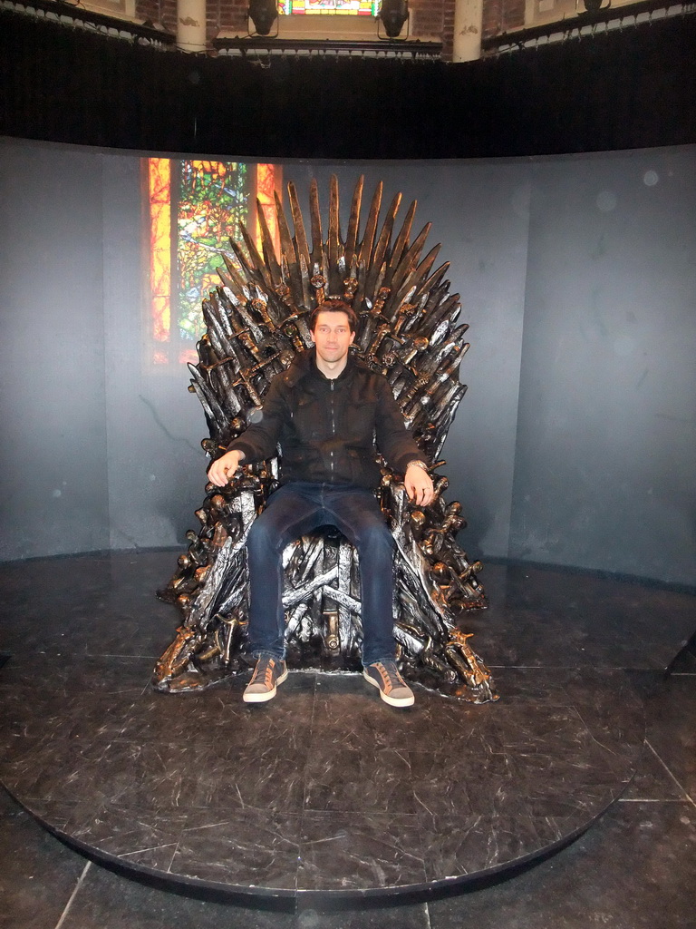 Tim sitting on the Iron Throne at `Game of Thrones: the Exhibition` at the Posthoornkerk church
