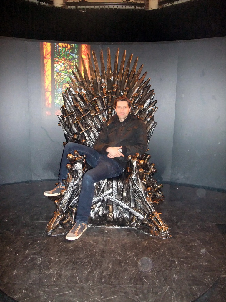 Tim sitting on the Iron Throne at `Game of Thrones: the Exhibition` at the Posthoornkerk church