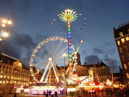 Ferris Wheel, other funfair attractions and the Royal Palace Amsterdam palace at the Dam square, by night