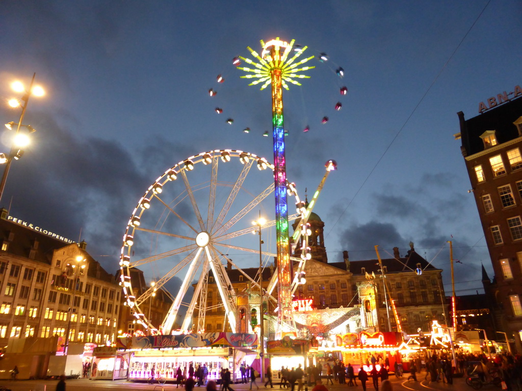 Ferris Wheel, other funfair attractions and the Royal Palace Amsterdam palace at the Dam square, by night