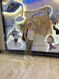 Miaomiao in front of a Land of Legends poster at the central hall of the Rixos Downtown Antalya hotel