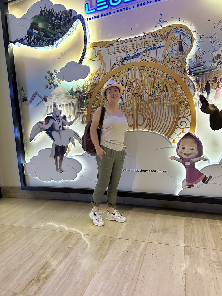 Miaomiao in front of a Land of Legends poster at the central hall of the Rixos Downtown Antalya hotel