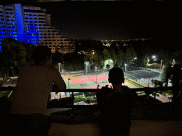 Miaomiao and Max at the balcony of our room at the Rixos Downtown Antalya hotel, with a view on the Sports fields and the Özkaymak Falez Hotel, by night