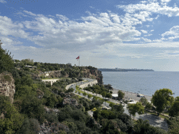 The Konyaalti Plaji road, flags, the city center and the Gulf of Antalya, viewed from the path at the top of the elevator from the Atatürk Kültür Park to the Beach Park