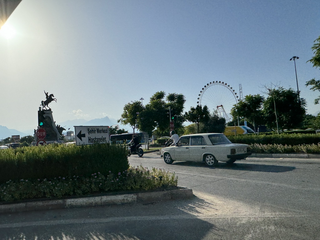 The Mustafa Kemal Ataturk Aniti monument and the Ferris wheel at the Aktur Park, viewed from the taxi at the Dumlupinar Boulevard