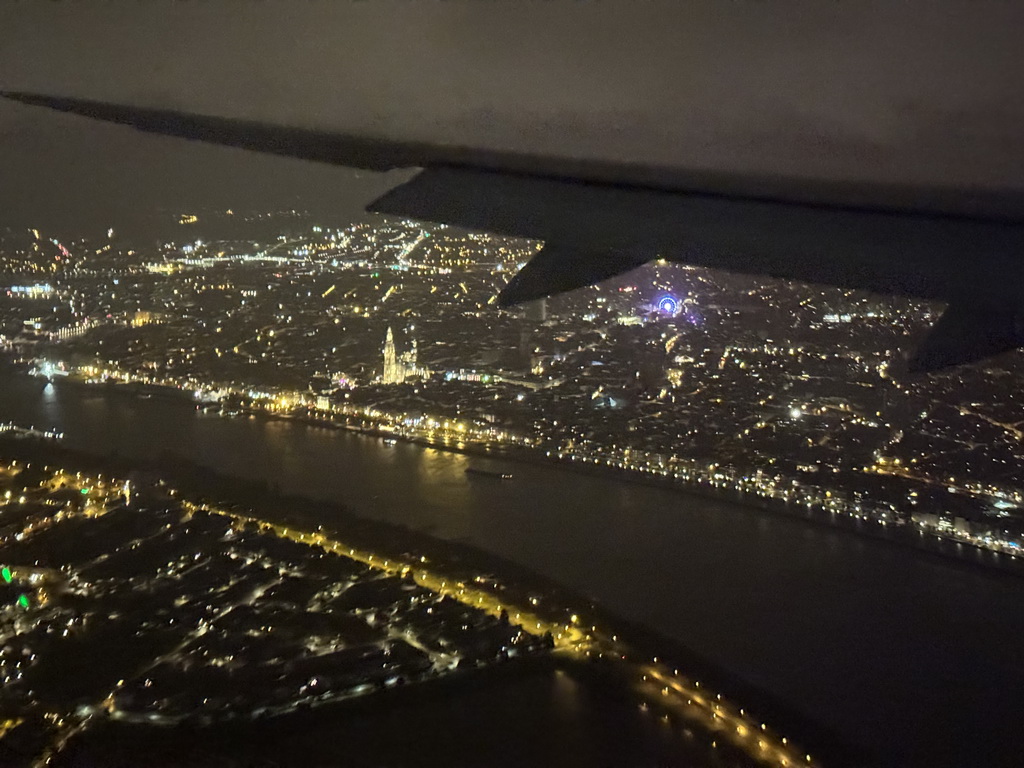 The city center of Antwerp with the Scheldt river, the Cathedral of Our Lady and a ferris wheel, viewed from the airplane to Antwerp, by night