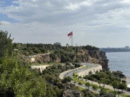 The Konyaalti Plaji road, flags, the city center and the Gulf of Antalya, viewed from the path at the top of the elevator from the Atatürk Kültür Park to the Beach Park