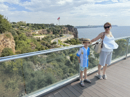 Miaomiao and Max at the path at the top of the elevator from the Atatürk Kültür Park to the Beach Park, with a view on the Konyaalti Plaji road, flags, the city center and the Gulf of Antalya