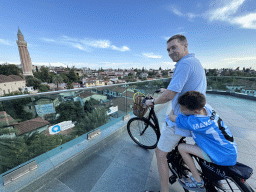 Tim and Max on their bicycle at the Republic Square, with a view on the city center with the Yivli Minaret Mosque and the Tekeli Mehmet Pasha Mosque