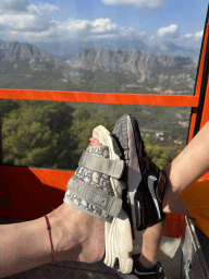 Miaomiao`s and Max`s feet at the Tünektepe Teleferik Tesisleri cable car, with a view on the hills on the north side of the Tünek Tepe hill