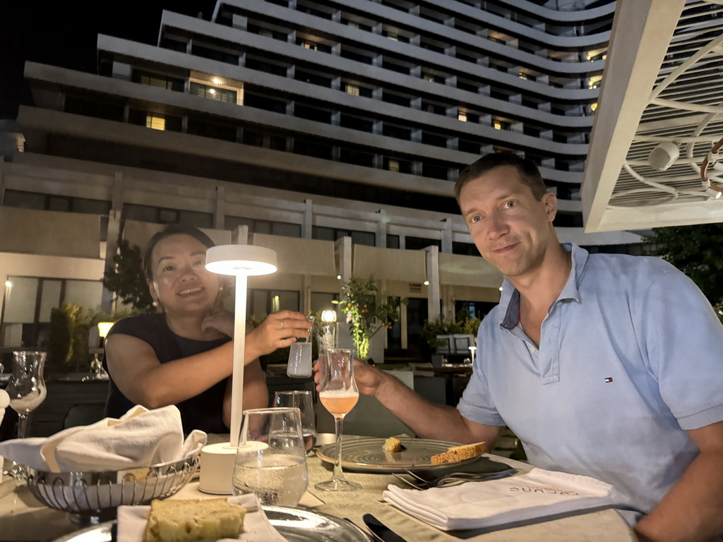 Tim and Miaomiao with a raki and a cocktail at the terrace of the Turunc restaurant at the garden of the Rixos Downtown Antalya hotel, by night