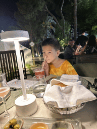 Max with a mocktail at the terrace of the Turunc restaurant at the garden of the Rixos Downtown Antalya hotel, by night