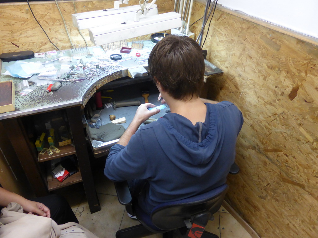 Man working on a diamond ring in the workshop of the Gela diamond shop at the Pelikaanstraat street