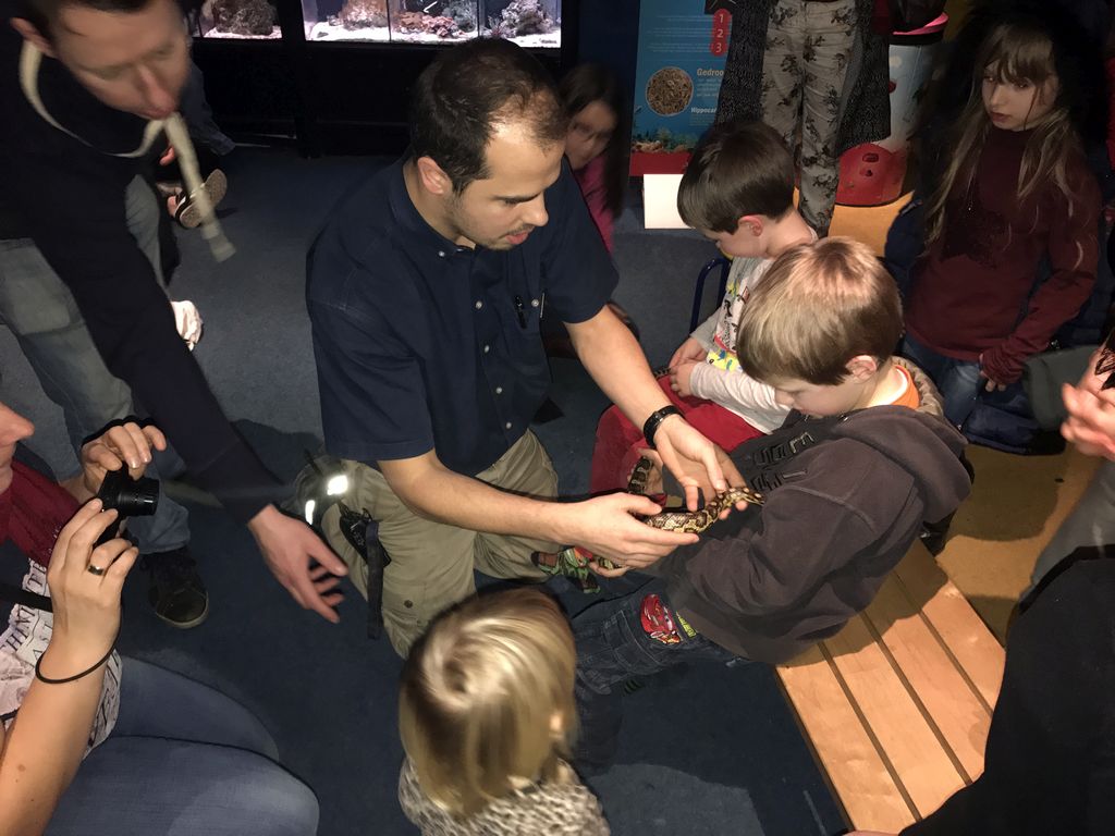 Zookeeper and kids with a snake at the Aqualabo at the Aquatopia aquarium