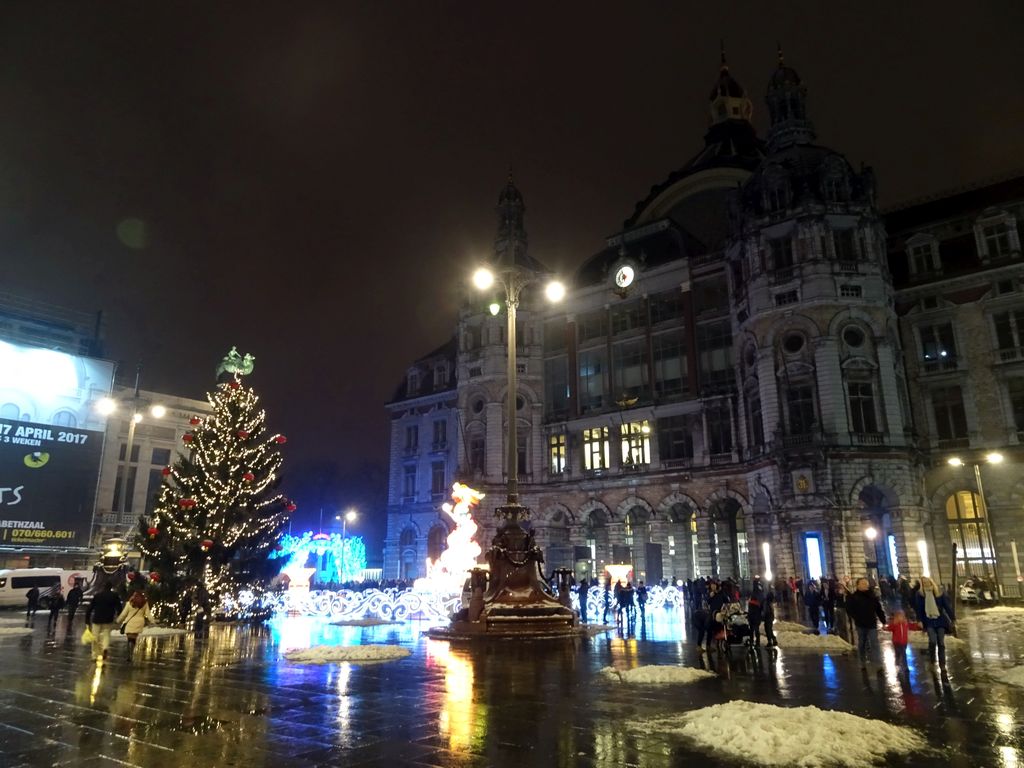 The Koningin Astridplein square with the front of the Antwerpen-Centraal railway station, the entrance to the Antwerp Zoo, a christmas tree and China Light statues, by night