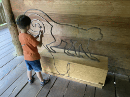 Max playing a buzz wire game at the upper floor of the Huis van NAAAP playground at the Apenheul zoo