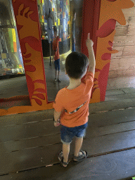 Max with a distoritng mirror at the upper floor of the Huis van NAAAP playground at the Apenheul zoo
