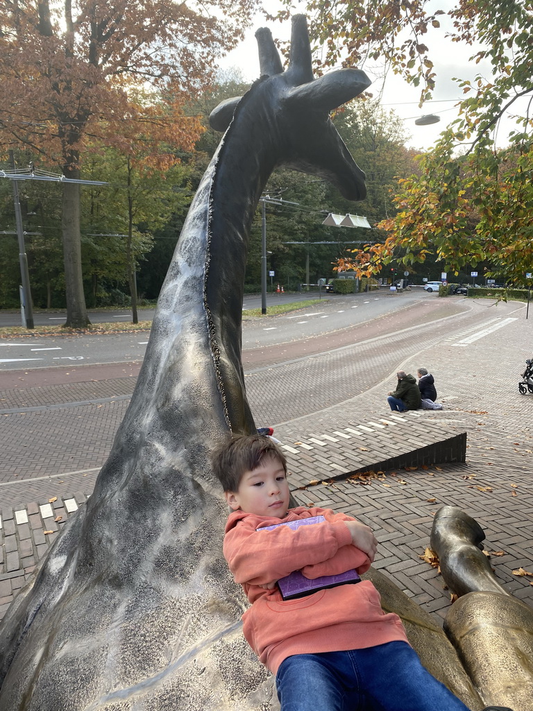 Max on the Giraffe statue at the entrance to Burgers` Zoo at the Antoon van Hooffplein square