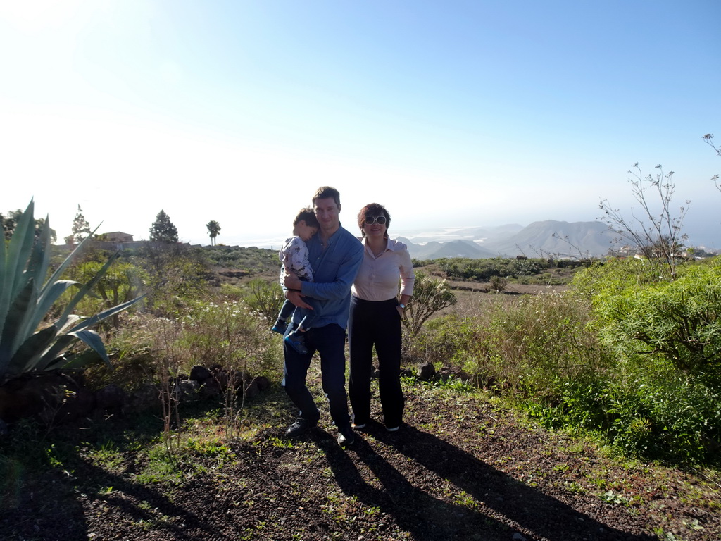 Tim, Miaomiao and Max on a parking place next to the Calle Camino-Real street, with a view on mountains and hills on the south side of the island