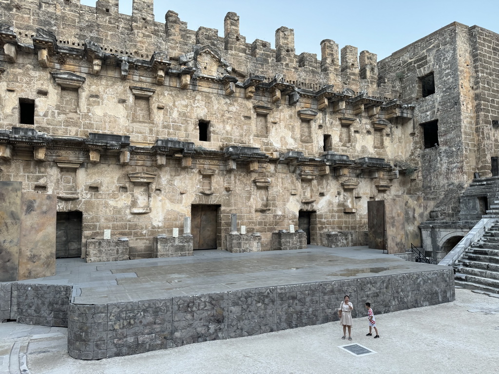 Miaomiao and Max with the orchestra, stage and stage building of the Roman Theatre of Aspendos, viewed from the northwest auditorium