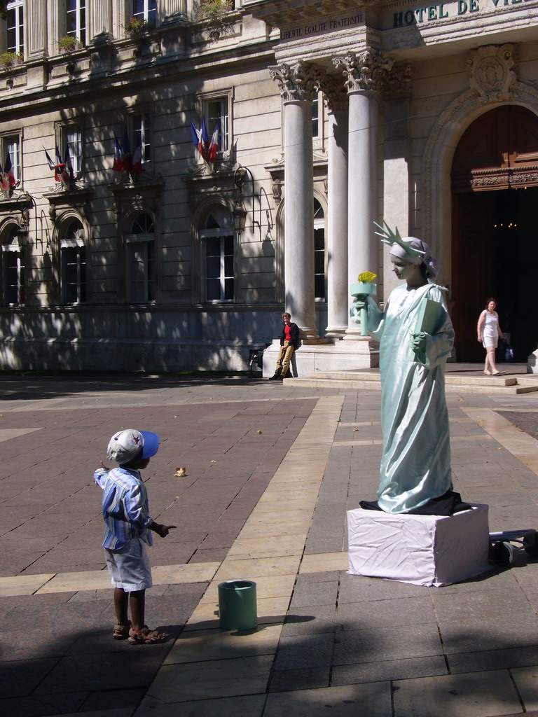 Living statue in front of the City Hall at the Place de l`Horloge square