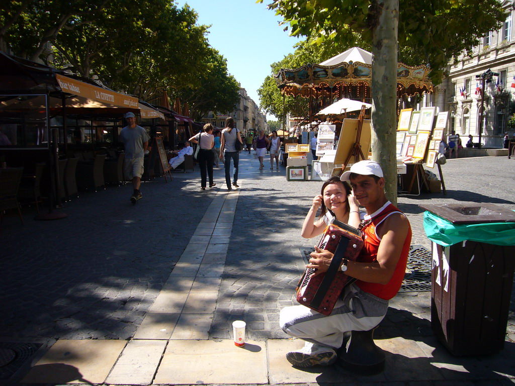 Miaomiao with street musician and carousel at the Place de l`Horloge square