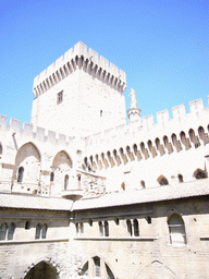 Walls and tower at the Cloister at the Palais des Papes palace, and the Gilded statue of the Virgin Mary at the top of the Avignon Cathedral