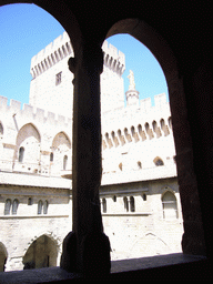 Window with a view on the Cloister at the Palais des Papes palace, and the Gilded statue of the Virgin Mary at the top of the Avignon Cathedral