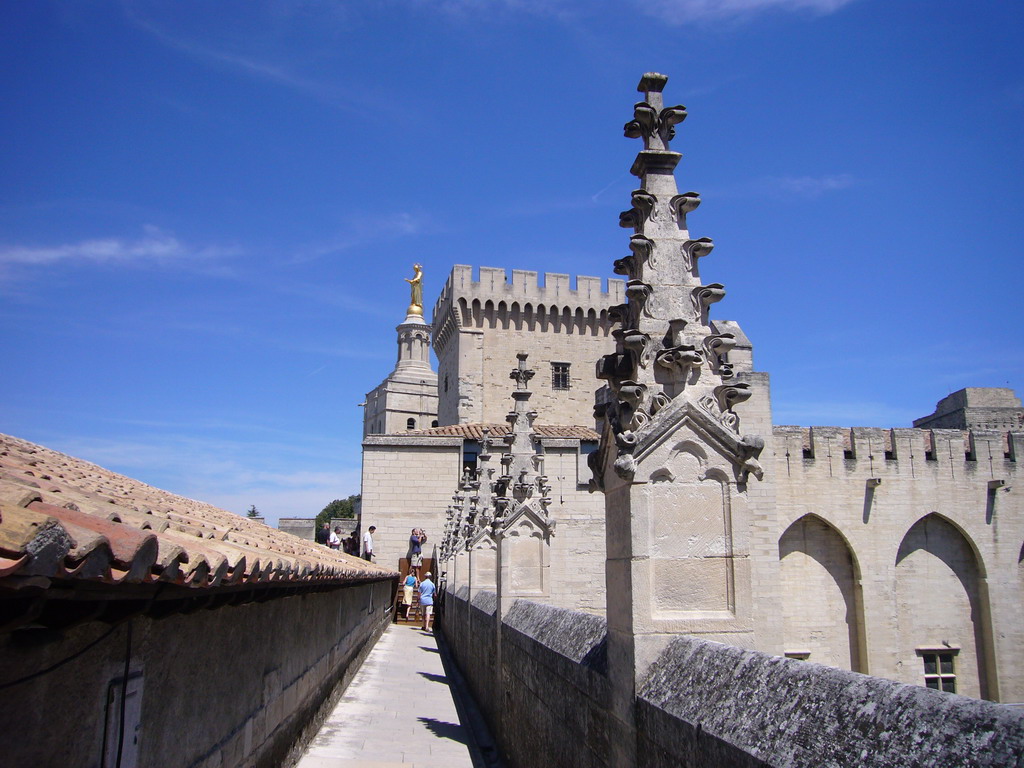 Roof and the Tour de la Campane tower of the Palais des Papes palace and the Gilded statue of the Virgin Mary at the top of the Avignon Cathedral, viewed from the roof of the Palais des Papes palace