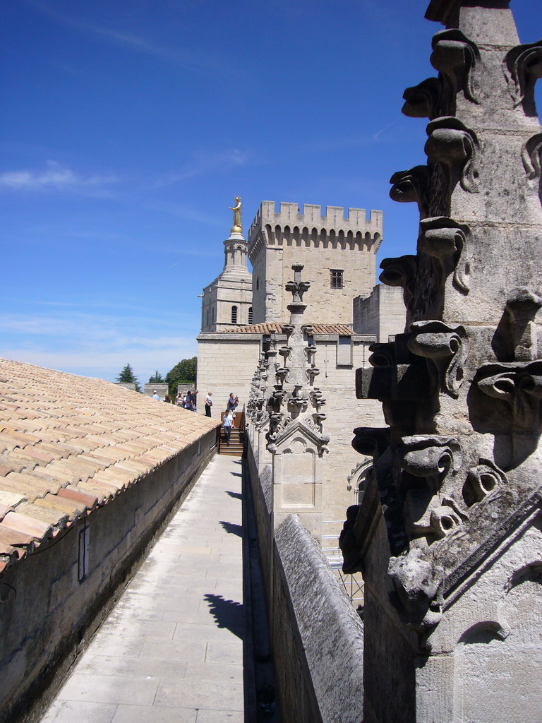 Roof and the Tour de la Campane tower of the Palais des Papes palace and the Gilded statue of the Virgin Mary at the top of the Avignon Cathedral, viewed from the roof of the Palais des Papes palace