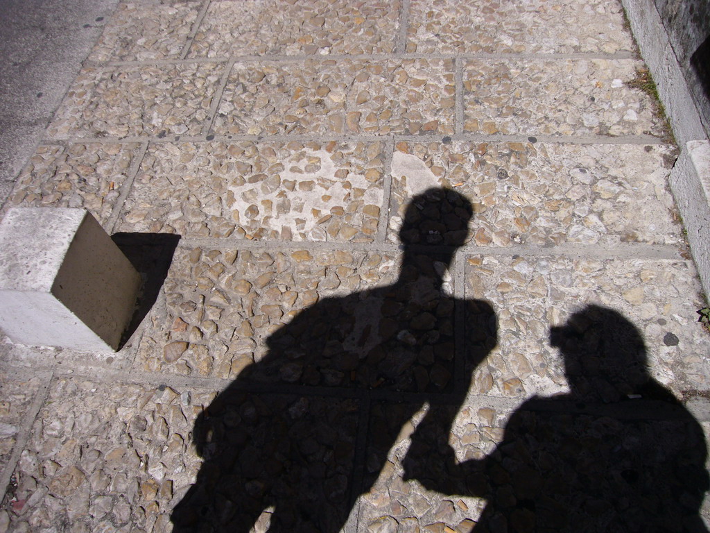 Tim`s and Miaomiao`s shadows at a street in the city center