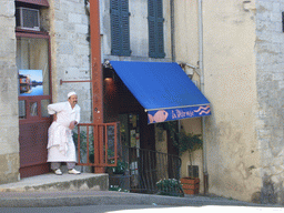 Cook in front of the La Petite Pêche restaurant at the Rue Saint-Etienne street