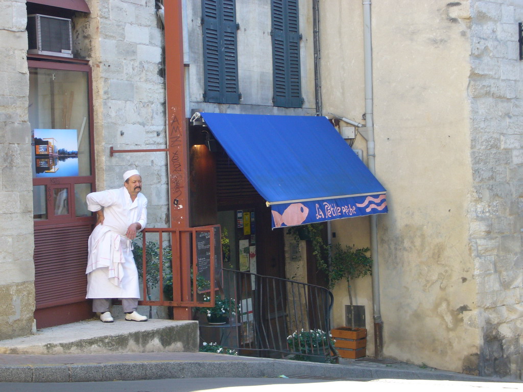 Cook in front of the La Petite Pêche restaurant at the Rue Saint-Etienne street