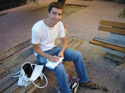 Tim writing postcards on a bench in the city center