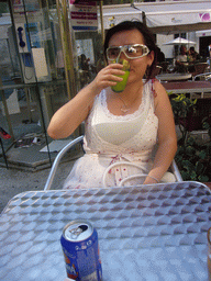 Miaomiao with a drink on square in the city center