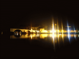The Pont Saint-Bénezet bridge over the Rhône river, the Rocher des Doms gardens, the Avignon Cathedral and the Palais des Papes palace, viewed from the Chemin de la Traille street, by night