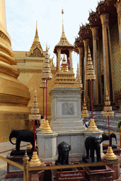 Column with elephants in front of the Phra Siratana Chedi stupa and the Phra Mondop hall at the Temple of the Emerald Buddha at the Grand Palace