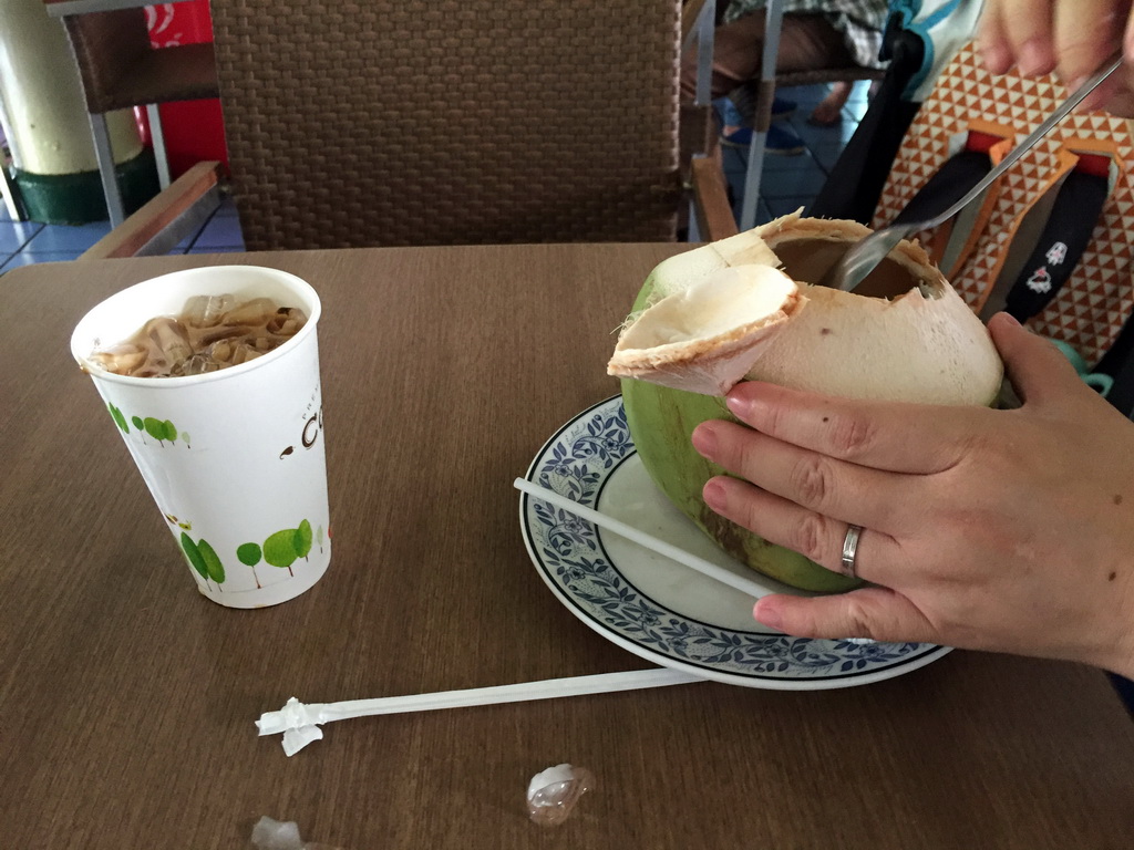 Miaomiao with a coconut and drinks in a restaurant at the west side of the Grand Palace