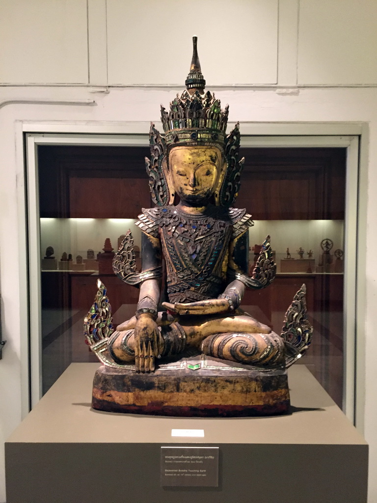 Statue of the Bejewelled Buddha Touching Earth, at the Asian Art room at the Ground Floor of the Maha Surasinghanat Building at the Bangkok National Museum, with explanation