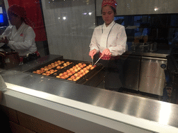 Woman preparing Takoyaki at the Paragon Food Hall at the Siam Paragon shopping mall