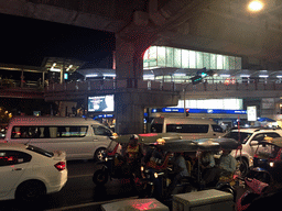 Rickshaws, cars and skywalk at Cha Loem Pao Junction, by night